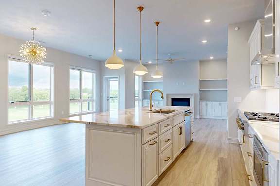 A kitchen with white cabinets and a large island.
