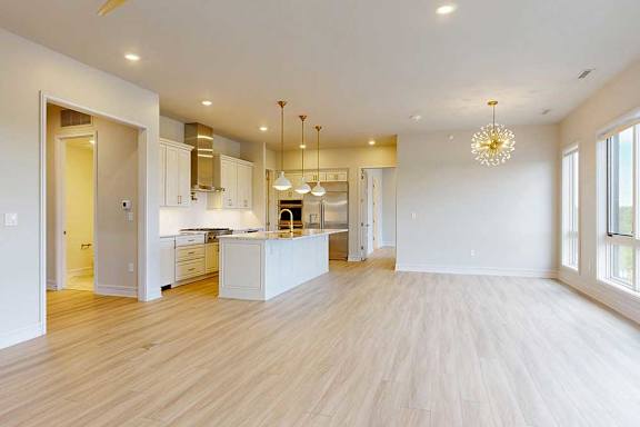 A spacious penthouse kitchen with white cabinets and a large island.