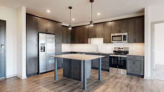 a modern kitchen with dark wood cabinets and stainless steel appliances