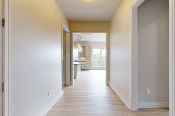 A hallway from the front door leading to the living room, with a door to the second bedroom, and a door to the hallway closet.