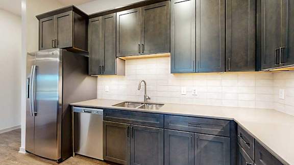 a kitchen with dark brown cabinets and stainless steel appliances