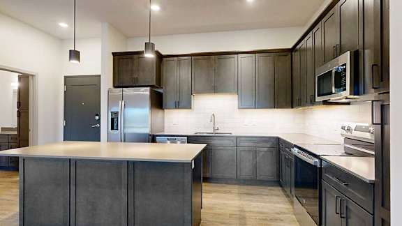 a modern kitchen with dark wood cabinets and stainless steel appliances