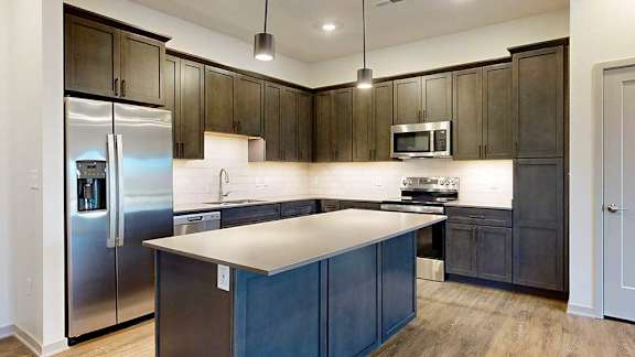 A kitchen with dark wood cabinets and stainless steel appliances.