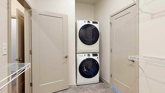 a stackable white washer and dryer in a laundry closet