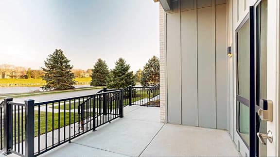 a walk-out patio with a black metal fence surrounding it