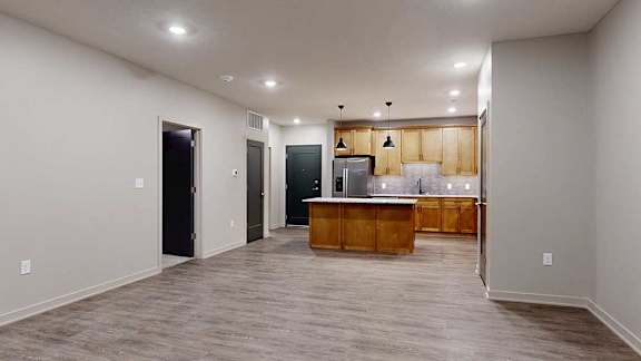 a living room with a kitchen in the background