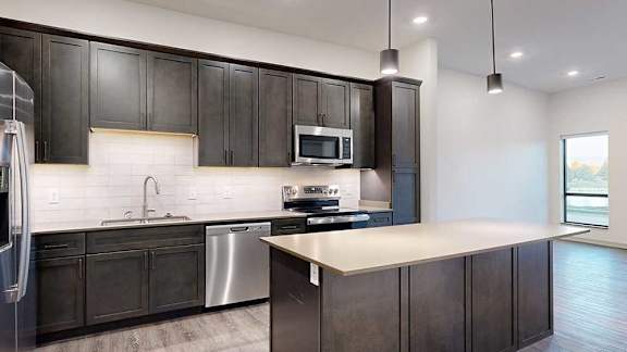 a modern kitchen with dark wood cabinets and stainless steel appliances