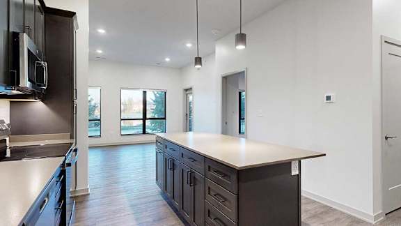 a modern kitchen with dark cabinets and a large island