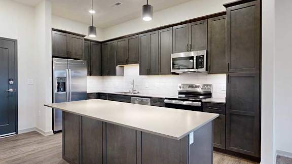 a modern kitchen with dark wood cabinets and stainless steel appliances
