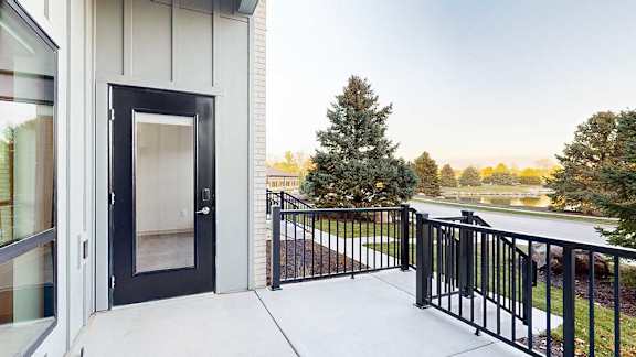 a black windowed door on a walk-out patio with a black metal railing