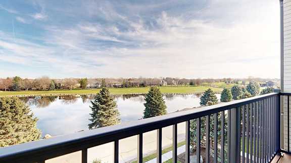 a balcony that overlooks a a pond and the Wilderness Ridge Golf Course