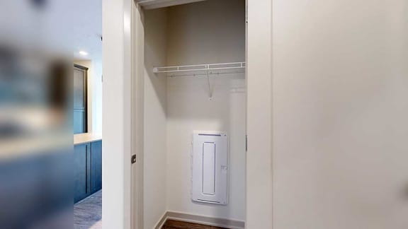 a coat closet with built-in shelving