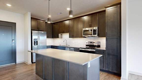 a modern kitchen with dark wood cabinets and stainless steel appliances