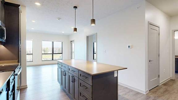 a kitchen with a large island and stainless steel appliances