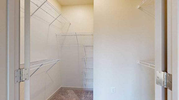 An oversized walk-in closet with several built-in wire shelves.