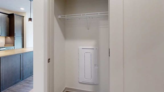 A hallway coat closet with a wire shelf.