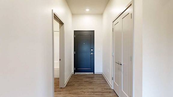 a front entry hallway with a door to a bathroom and another to a hallway closet