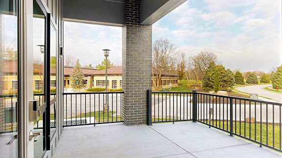 a balcony with a black metal railing and a brick pillar