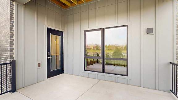 a walk-out patio with a large window and a black windowed door