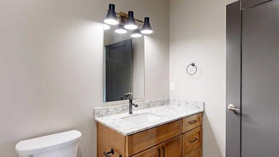 a bathroom with a white quartz sink and a mirror