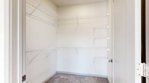 An oversized walk-in closet with several built-in wire shelves.