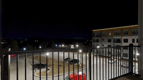 a balcony with a view of the surrounding neighborhood at night