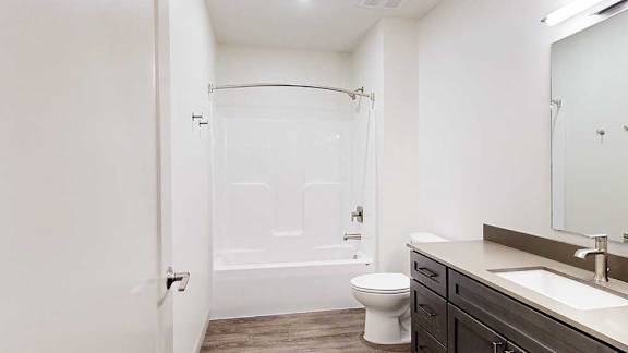 a bathroom with a white shower and tub