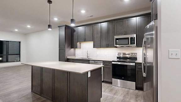 a modern kitchen with dark wood cabinets and stainless steel appliances