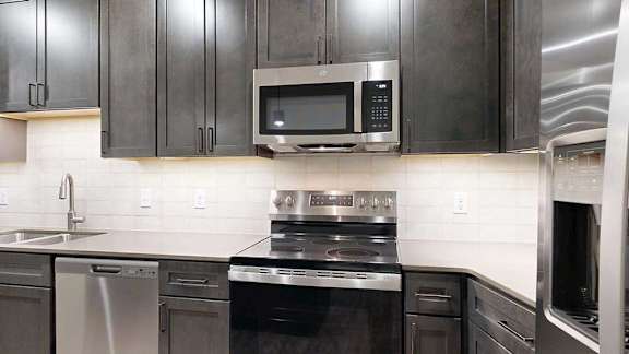 a modern kitchen with a stainless steel range and microwave