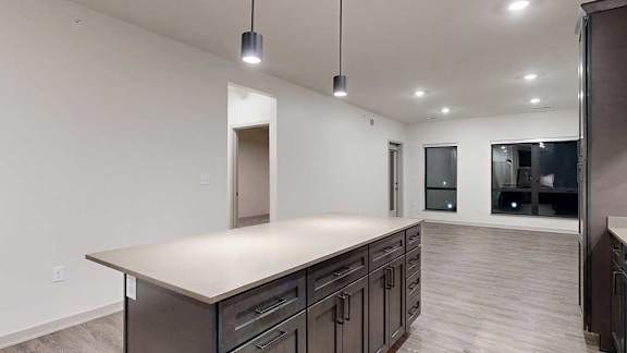 a kitchen with a large island and dark wood cabinets