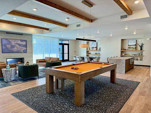 A pool table in the middle of a room with a fireplace and a TV