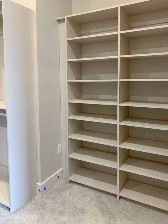 built-in shelves with several levels in a spacious walk-in closet