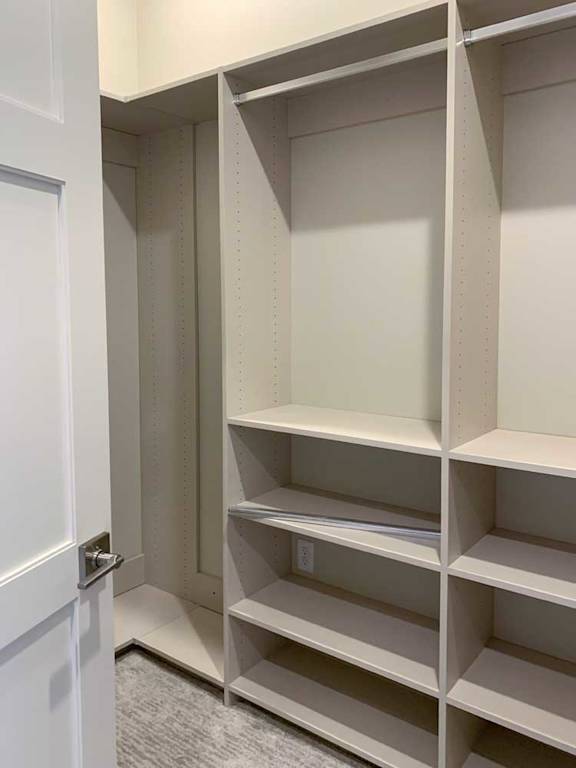 an additional closet with built-in shelving and hanging spaces, attached to the primary walk-in closet of the primary bedroom