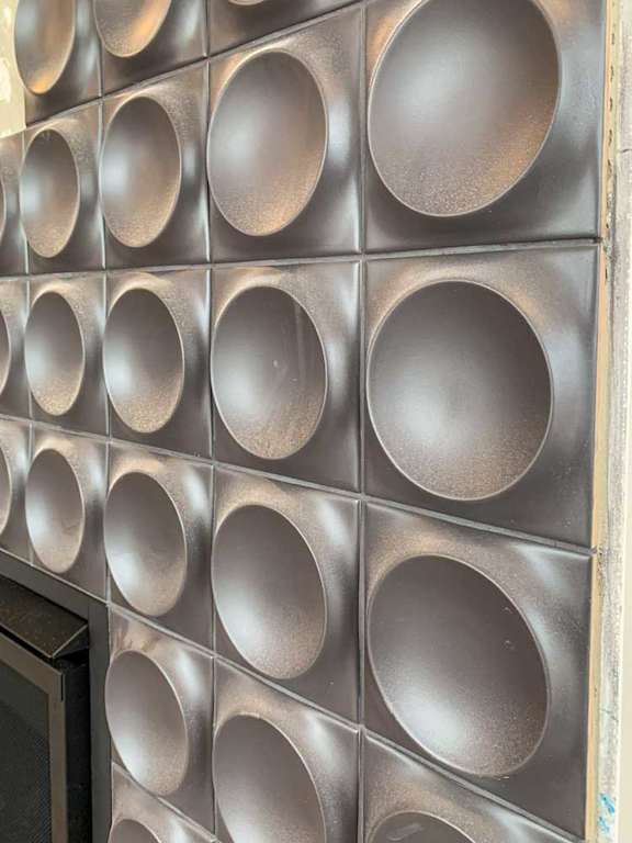 a fireplace accent wall with a series of circular tiles