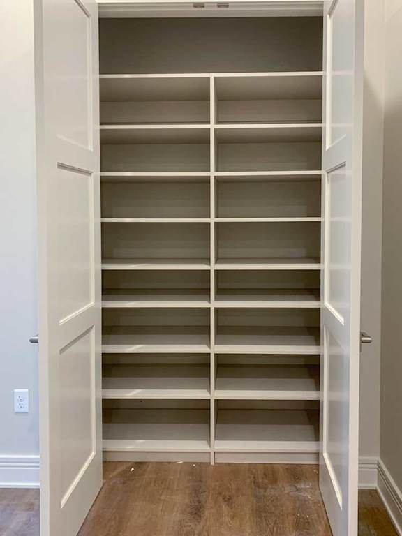 a hall closet with several built-in shelves