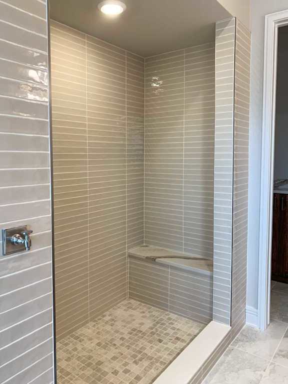 a tiled walk-in shower with a built-in bench for seating