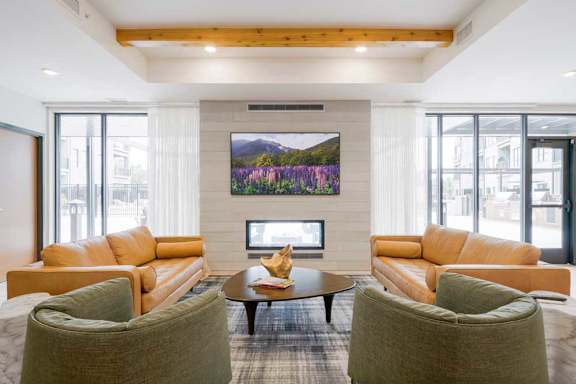 A clubroom with a TV lounge, two-way fireplace, and lounge seating.