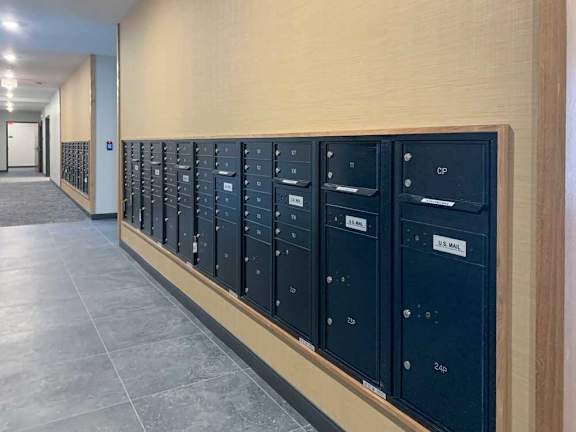 a row of black mailboxes are lined up on a wall next to the fitness center