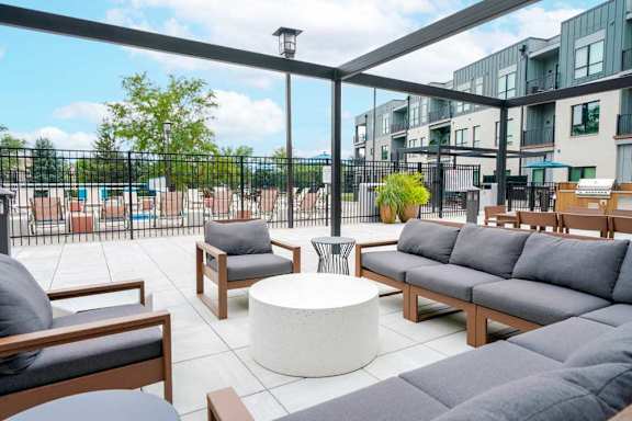 A courtyard patio with lounge seating and a pergola frame.