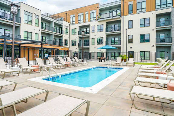 A lounge pool surrounded by several lounge chairs and umbrellas for shade.