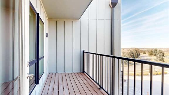 A balcony with a metal railing and a view of the neighborhood.