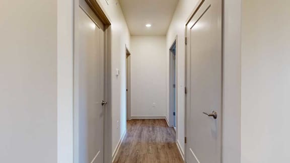 A hallway with closets on either side.