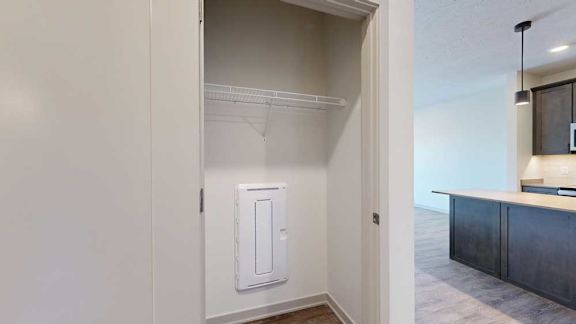 A hallway coat closet with a wire shelf.