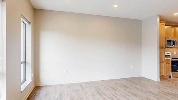 a living room with hardwood flooring and large windows