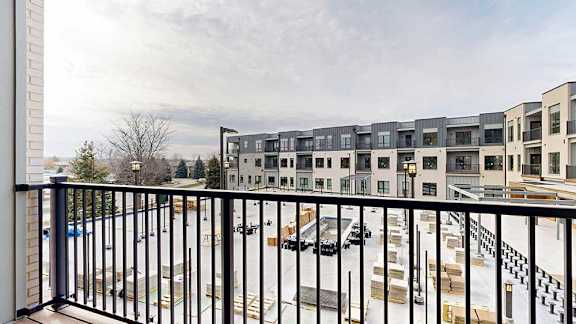a balcony with a black metal railing, and a view of the courtyard space