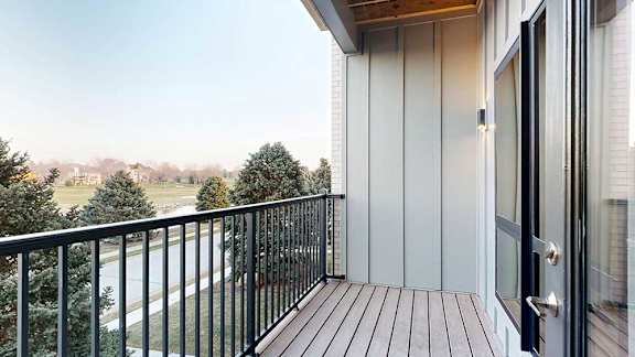 a balcony with a black railing and a view of the pond