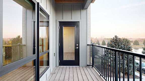 a balcony with a window to the bedroom and a windowed door to the living room