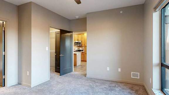 a bedroom with a carpeted floor, ceiling fan, and walk-in closet