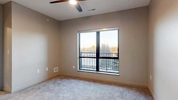 a bedroom with a window and a ceiling fan
