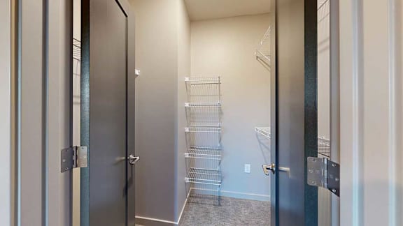 a walk-in closet with multiple built-in shelves and hanging space